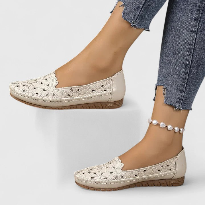 Close-up detail of perforated pattern on women's slip on flats with smooth upper finish