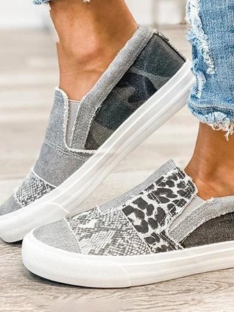 Side angle of women's slip-on sneakers with frayed canvas edges and mixed animal print design on flexible sole