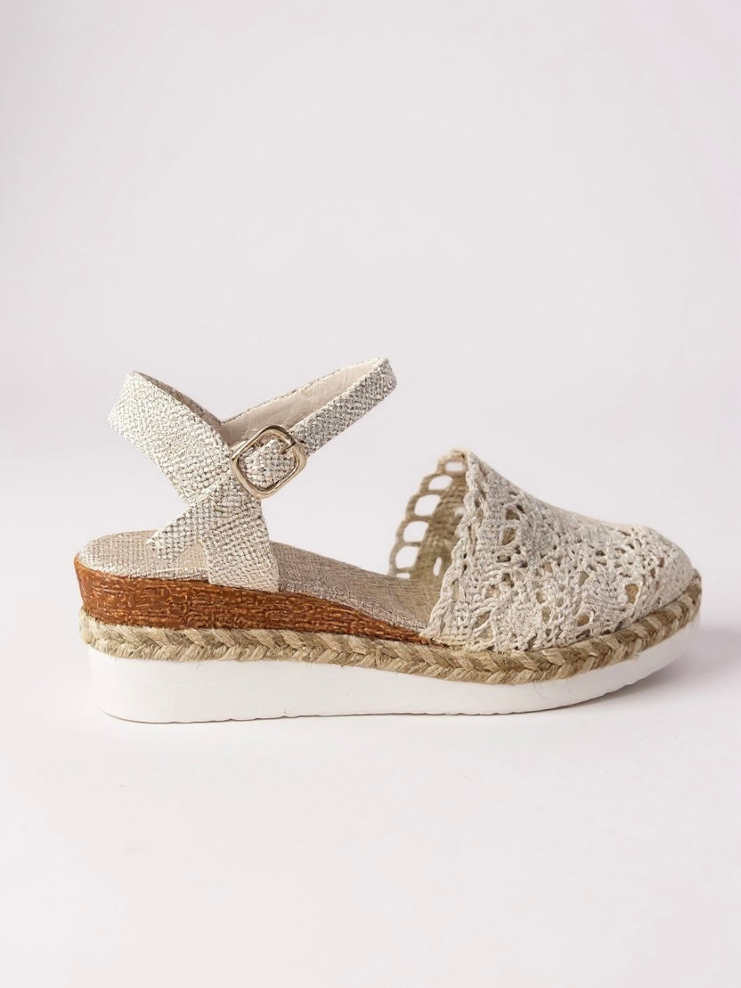Close-up of crochet cutout detailing on boho wedge espadrille ankle strap sandals with textured finish