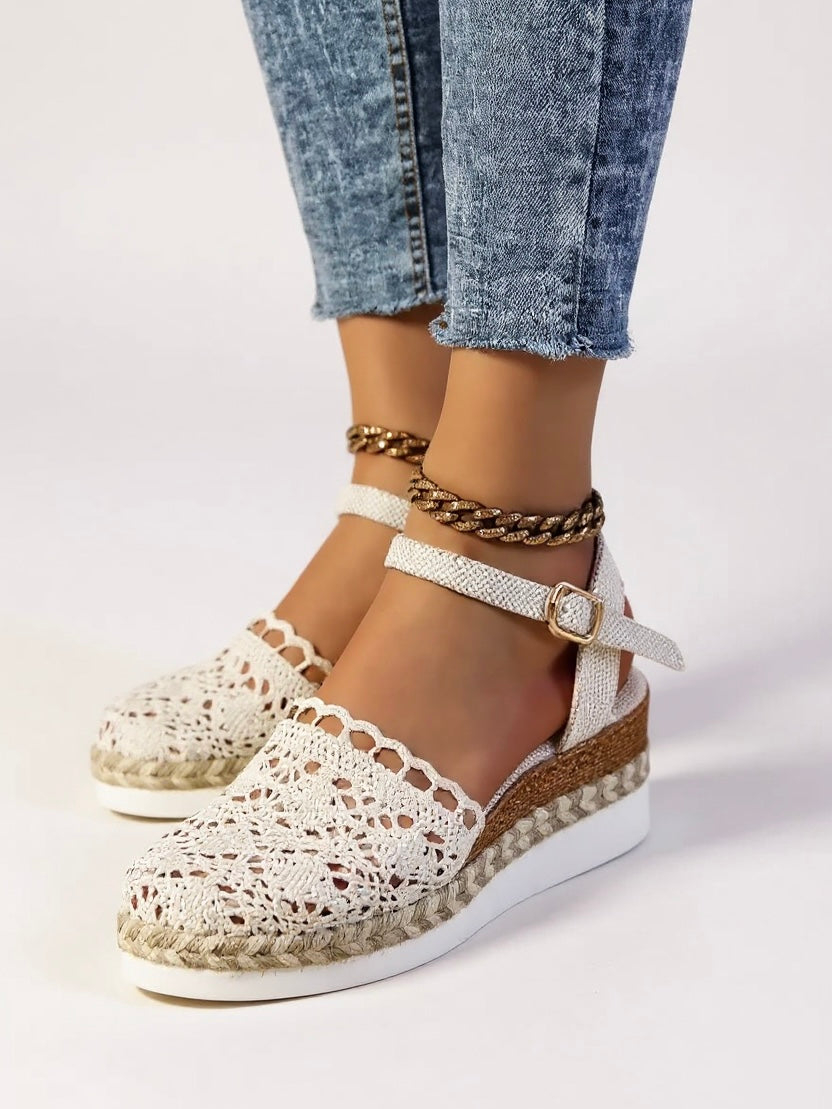 Detail shot of adjustable ankle strap with chain accent on boho wedge espadrille sandals