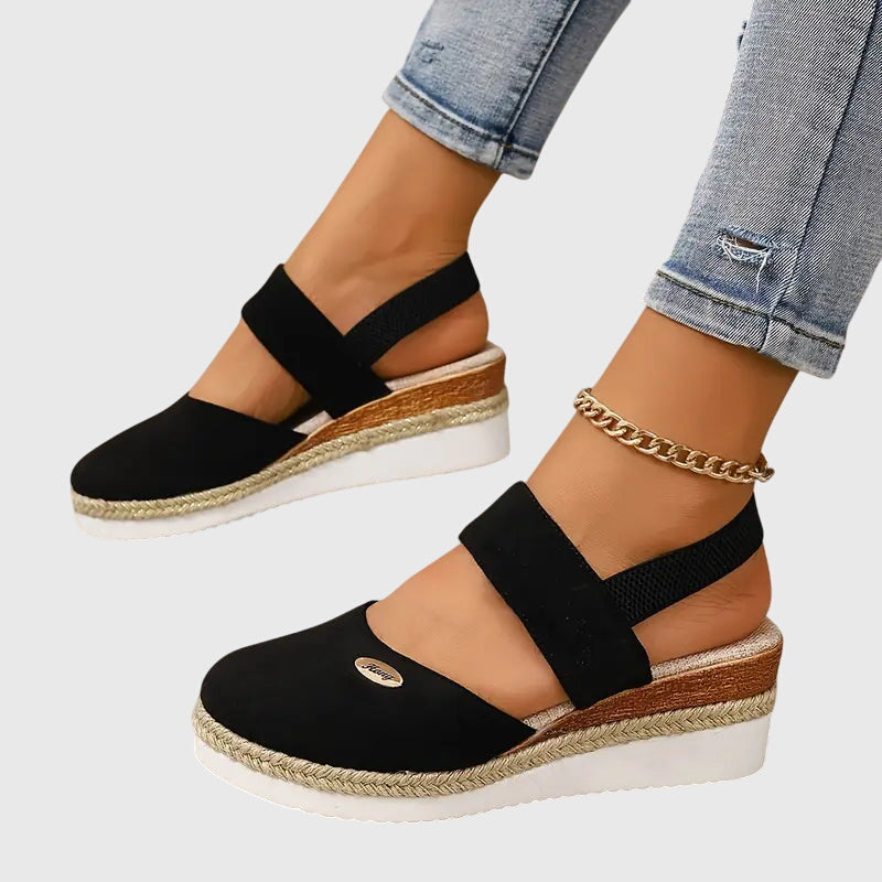 Women's platform sandals with espadrille-wrapped sole and elastic straps worn with white socks