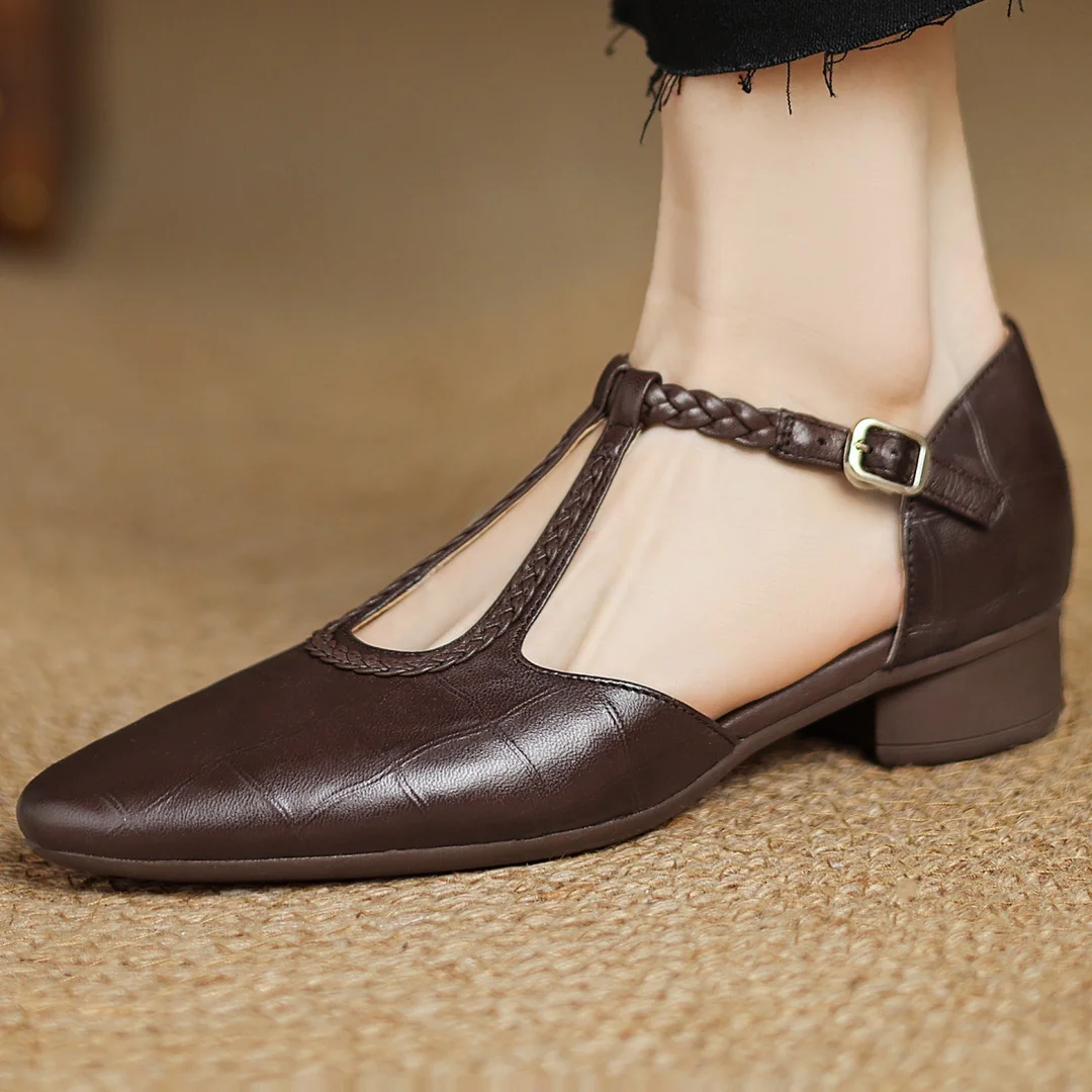 Women's leather mary jane flats with pointed toe and adjustable buckle worn with black trousers