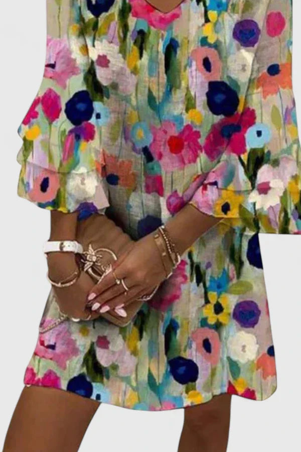 Close-up view of floral midi dress showing colorful abstract print in pink blue yellow and green tones