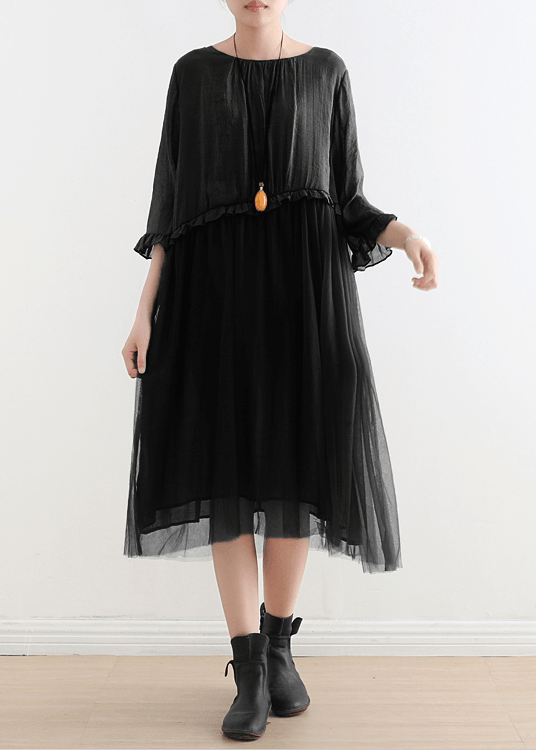 Woman wearing dusty blue summer dress with tulle overlay paired with black footwear