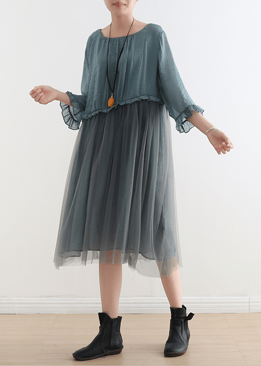Full-length view of woman in dusty blue tulle maxi dress paired with black ankle boots