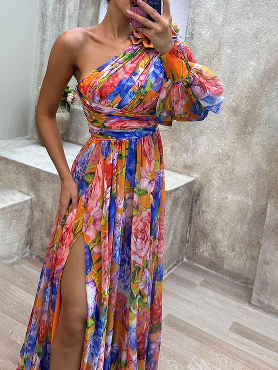 Flowing maxi dress featuring one shoulder design, high slit, and pink and green floral pattern
