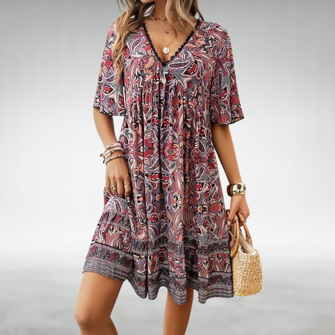 Close-up detail of V-neckline and vibrant paisley pattern on women's mini dress