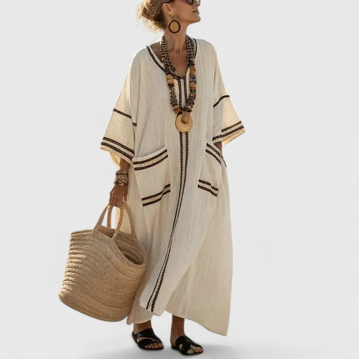 Woman wearing an Elegant Bohemian Dress in beige with contrast stripe trim and V-neckline