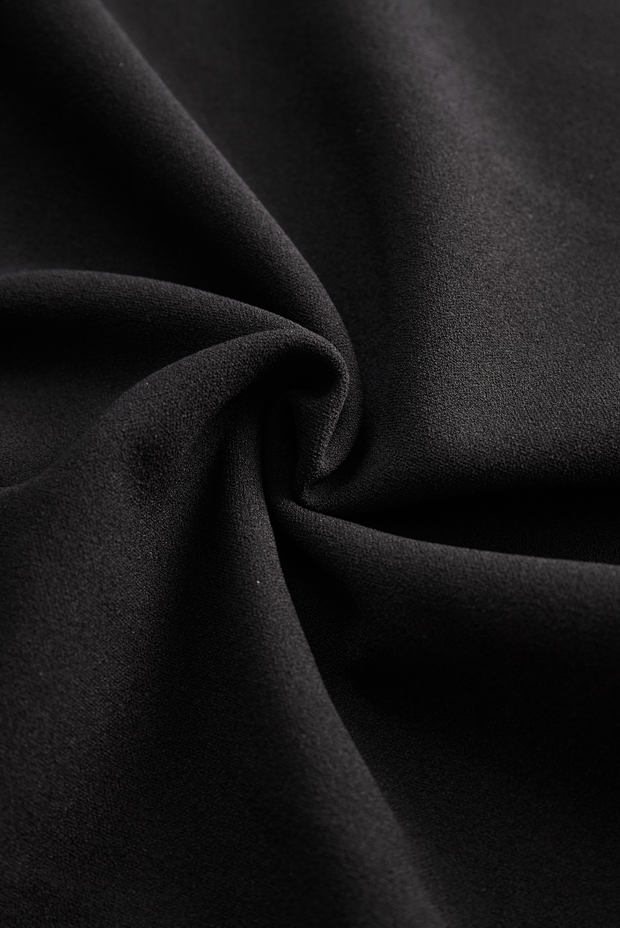 Detail of refined midi dress fabric showing smooth finish and structured drape