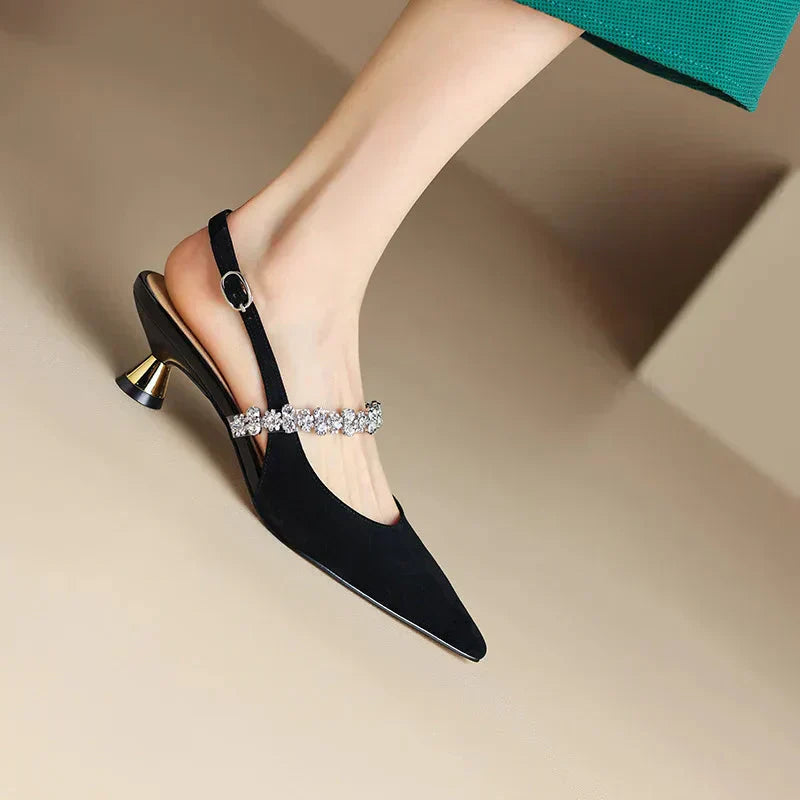 Close detail of sparkling crystal embellishment on metallic slingback heel instep strap