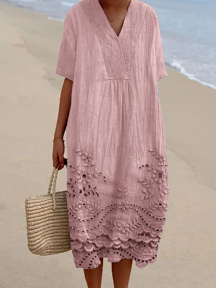 Flowing midi summer dress with gathered waist and short sleeves shown in relaxed beach setting