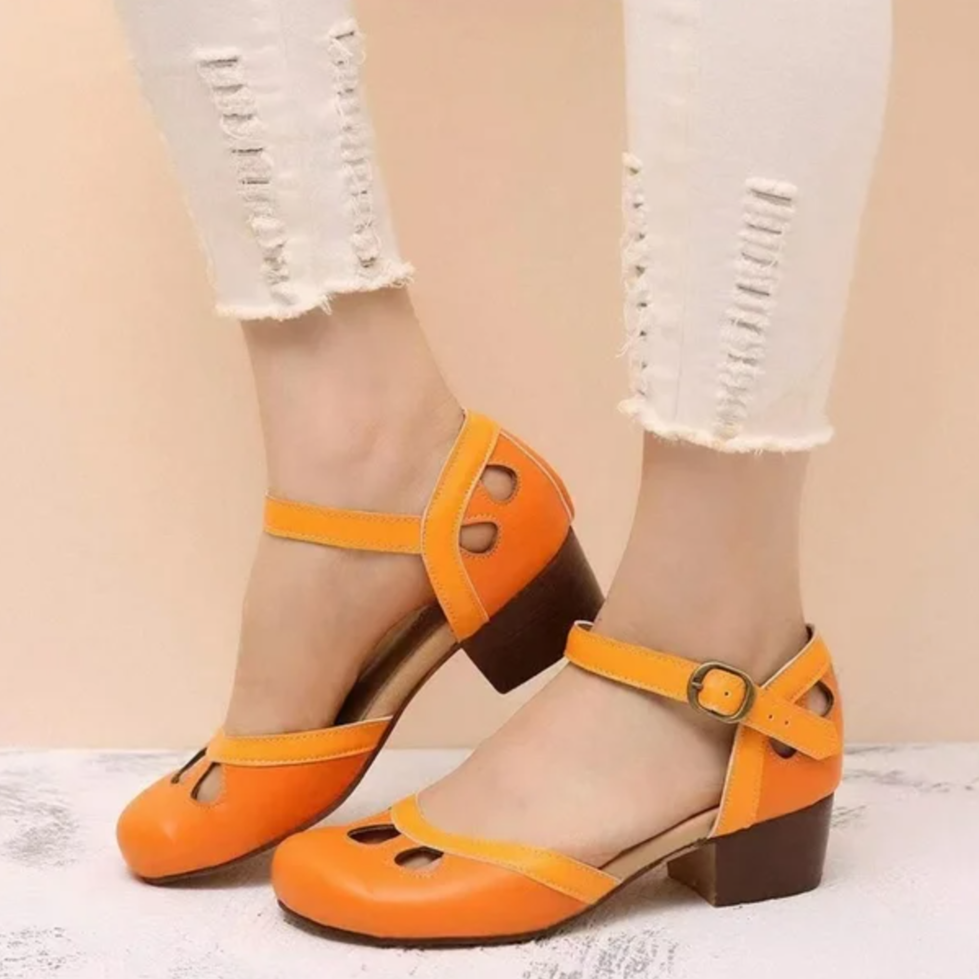Close-up view of women's low-heeled sandals showing three cutout details and buckle ankle strap