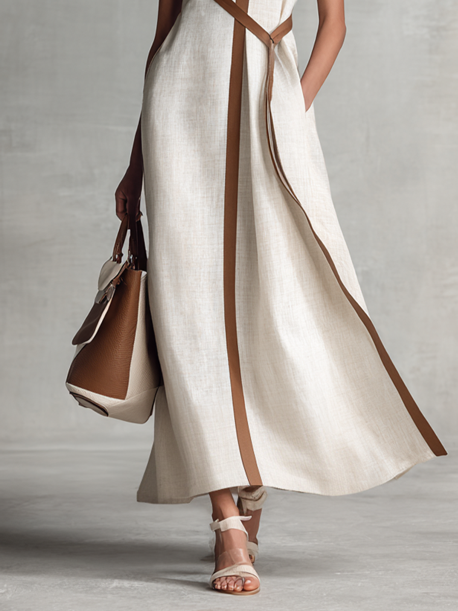 Elegant maxi dress with V-neckline and contrast trim styled with heeled sandals and tote bag