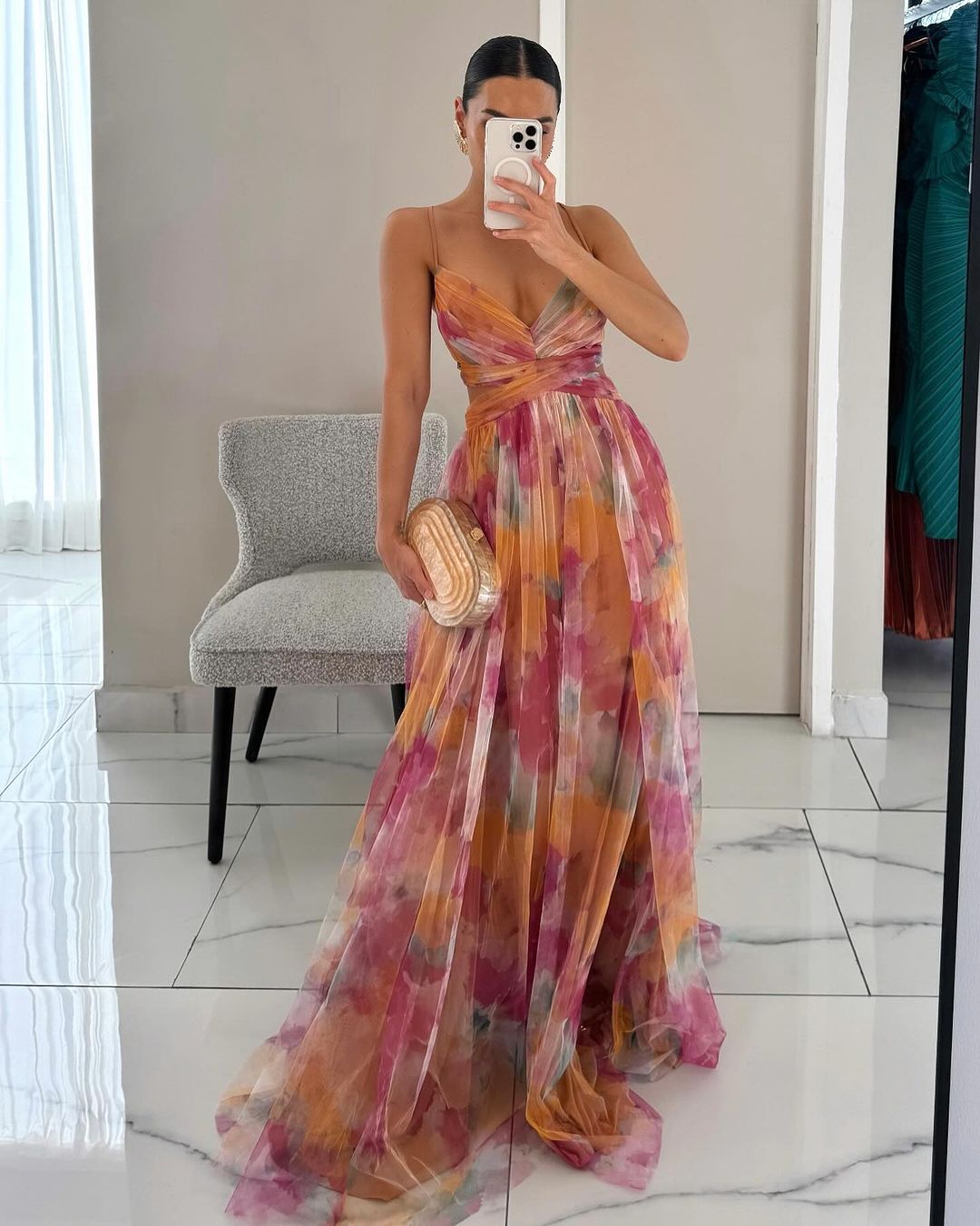 Woman wearing floral print maxi dress with sweetheart neckline and flowing skirt in watercolor tones