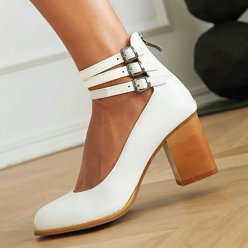 Women's smooth sandals with ankle strap and thick heel on textured pavement surface