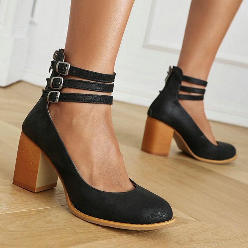 Close-up of smooth sandals with ankle strap and thick heel showing triple buckle detail