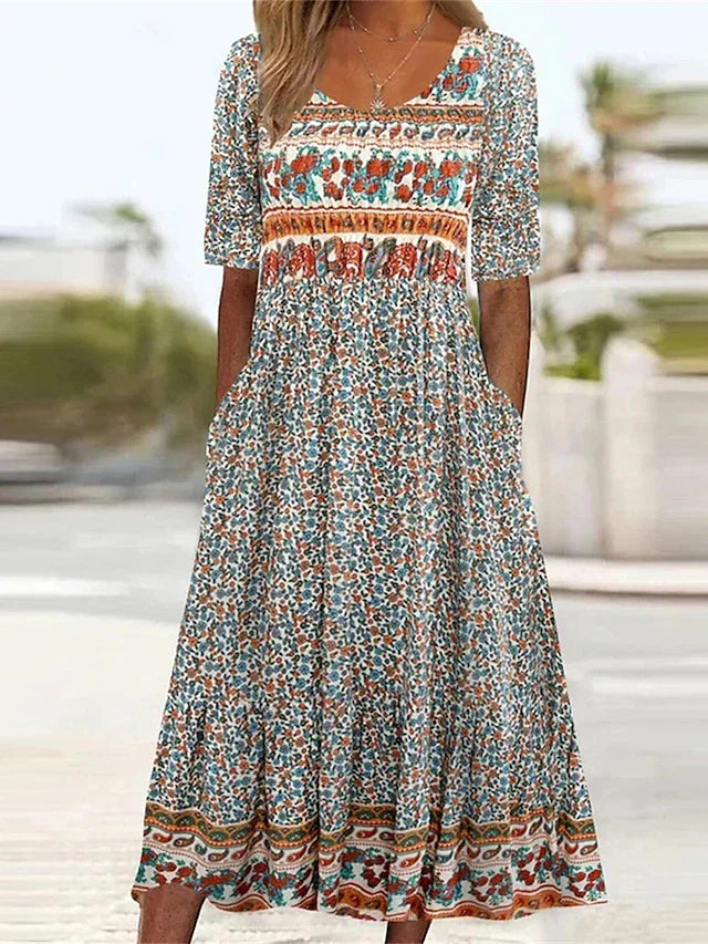 Sarah wearing a Boho Print Midi Dress with square neckline, empire waist, and mixed bohemian print panels in outdoor setting