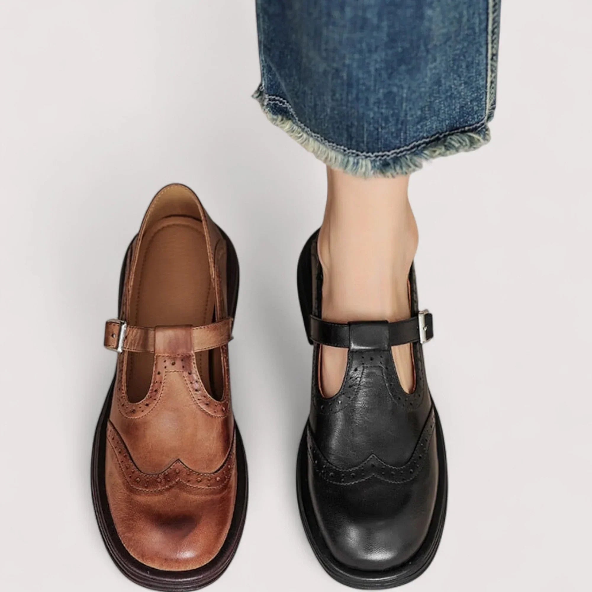 Pair of brown mary jane shoes with rounded toe and supportive footbed on neutral background