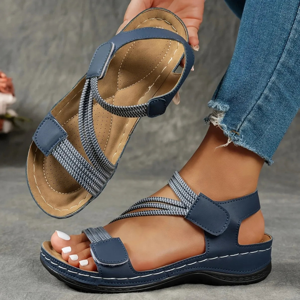 Full view of women's casual sandals with adjustable straps and cushioned sole in beige colorway on model foot
