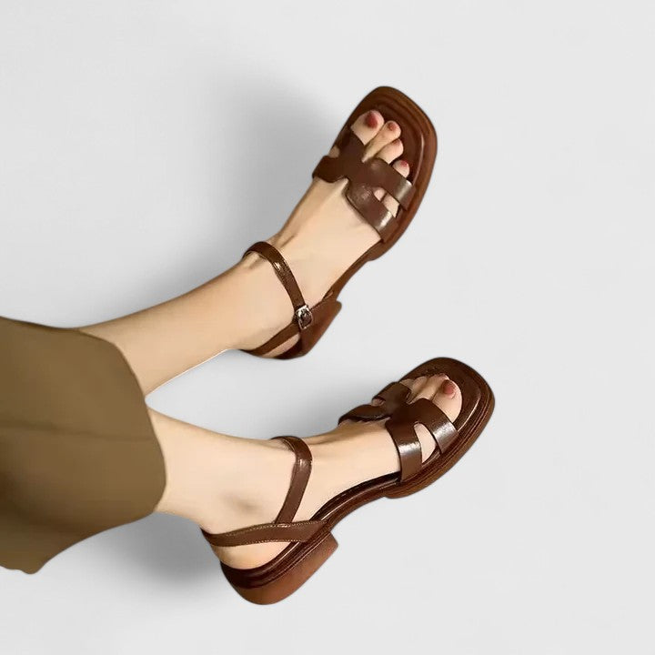 Detail of adjustable buckle ankle strap on sophisticated flat sandals with cushioned insole