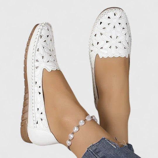 Side view of women's perforated slip on flats showing elastic goring and flat rubber sole