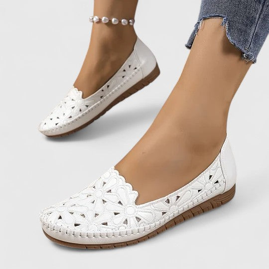Women's perforated slip on flats in white showing breathable cutout design and closed-toe coverage