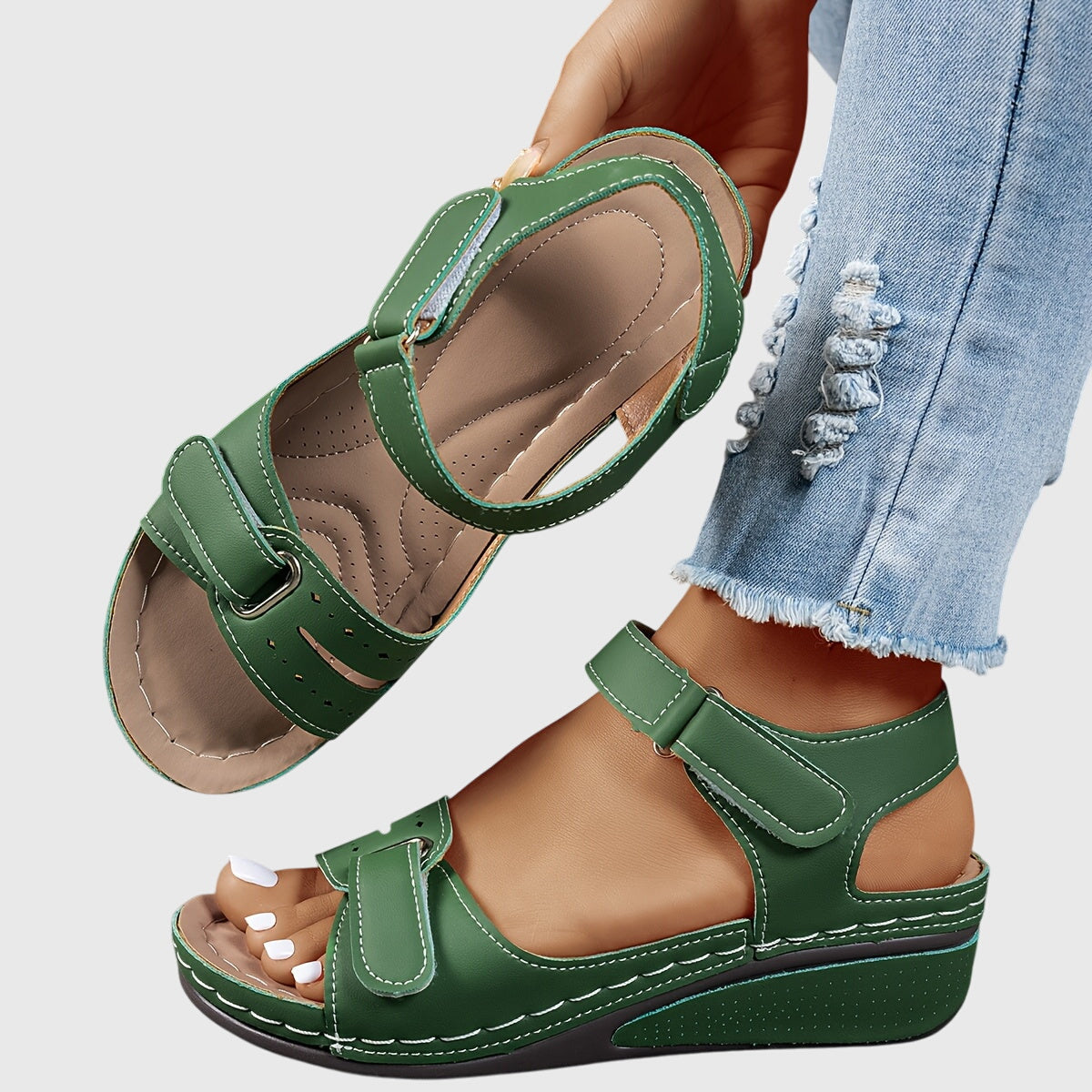 Close-up of red orthopedic sandals showing hook-and-loop closures and perforated footbed detail