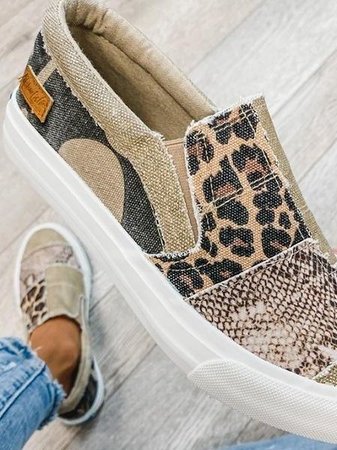 Women's loafers with animal print canvas upper and white toe cap, styled with black pants for casual wear