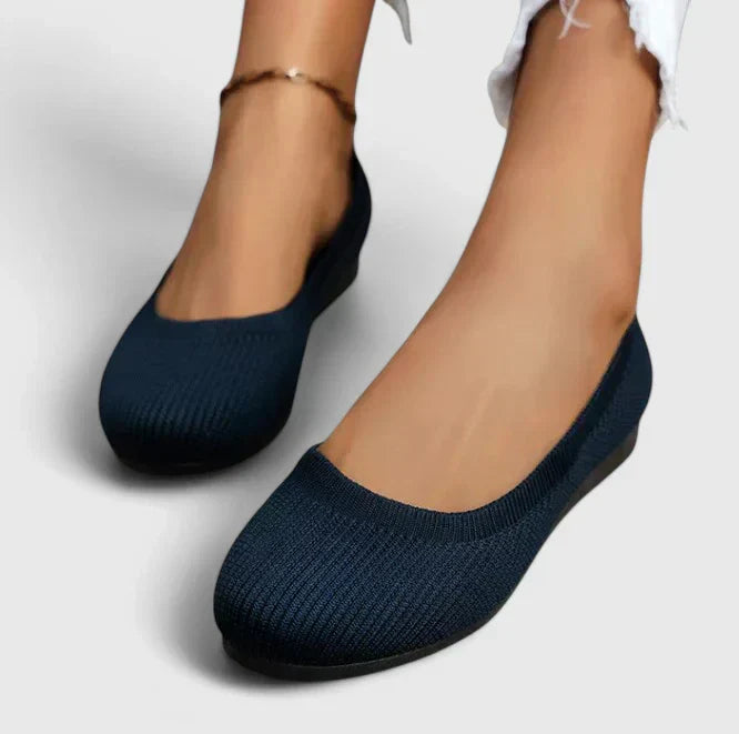 Side profile of women's orthopedic slip on shoe showing textured knit upper and flat cushioned footbed