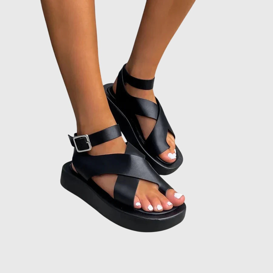 Full view of women's gladiator platform sandals on foot displaying adjustable ankle strap and open-toe silhouette in coral orange