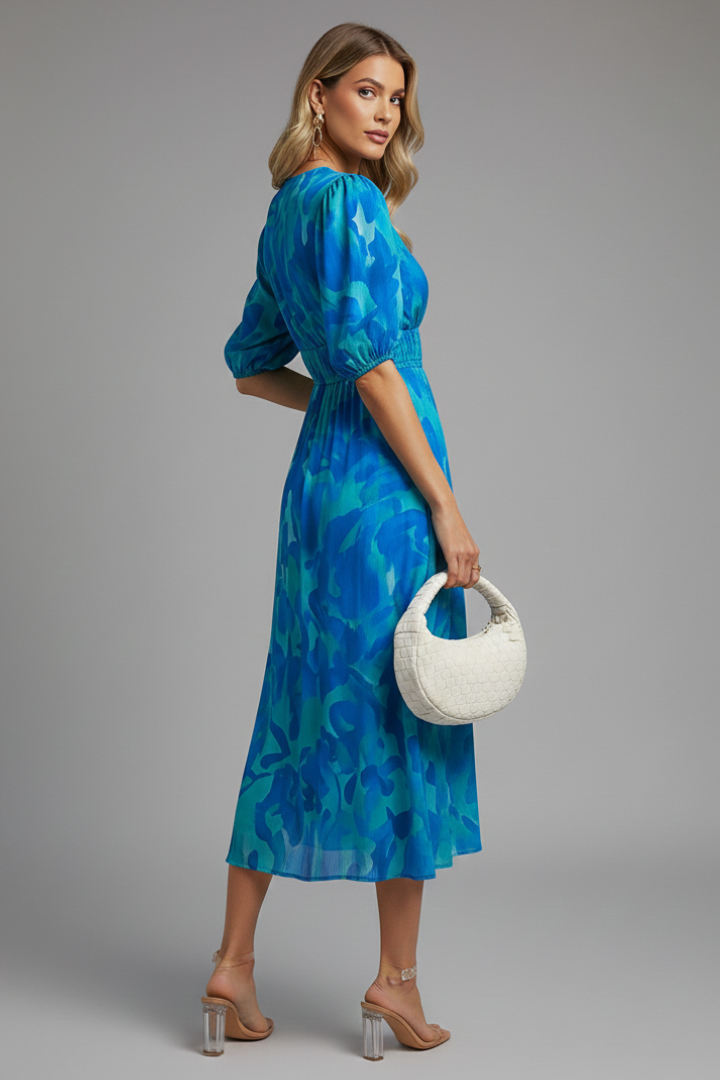 Side view showing puff sleeve construction and natural drape of floral midi dress in blue tones