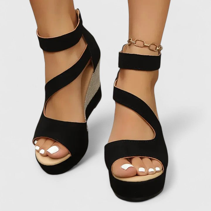 Side angle of women's wedge sandals displaying cushioned footbed and woven wedge heel construction