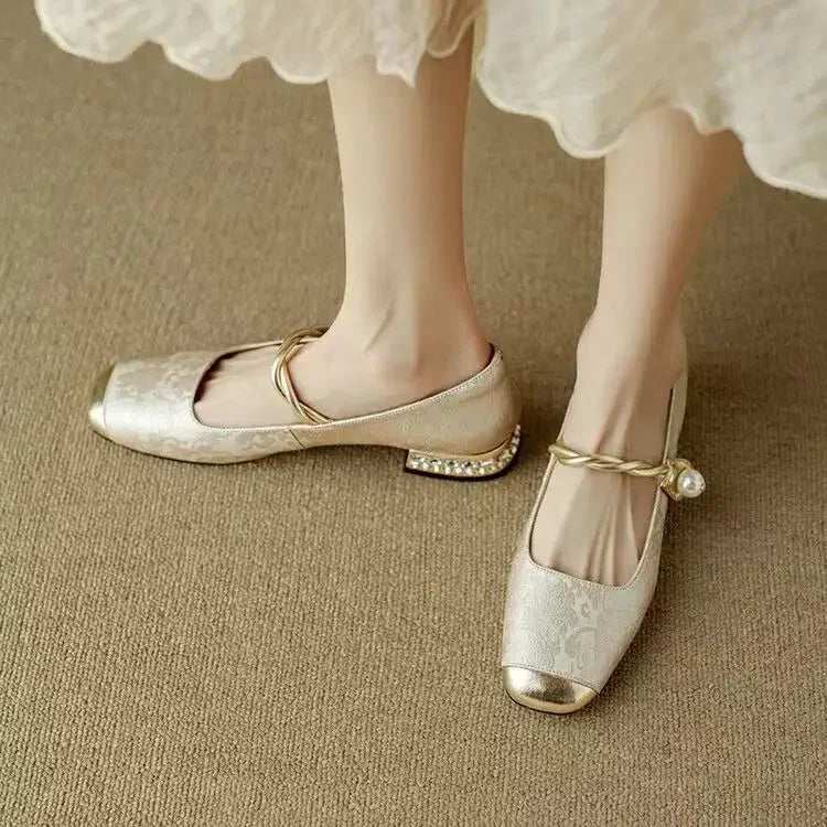 Model holding sage green Mary Jane shoe showing pearl strap and metallic square toe construction