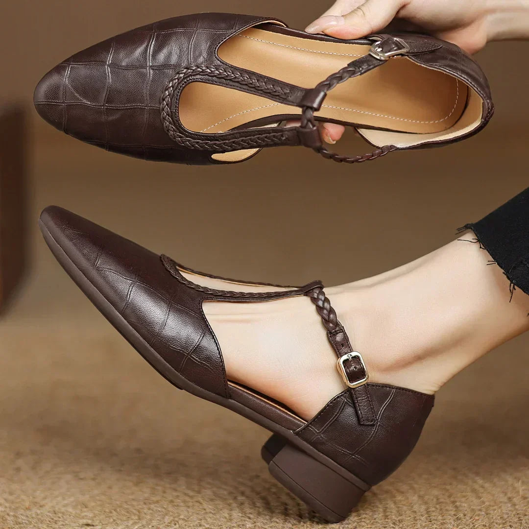 Close-up view of pointed toe and braided T-strap detail on women's leather mary jane flats