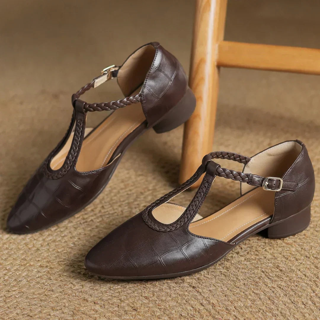 Top view of dark brown leather T-strap mary jane flats showing braided strap design