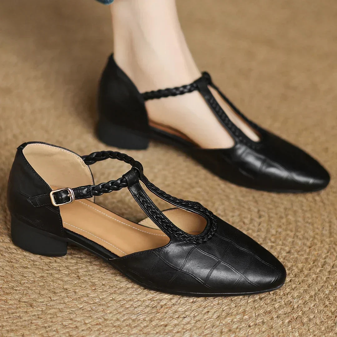 Women's leather T-strap flats styled with casual denim showing pointed toe silhouette