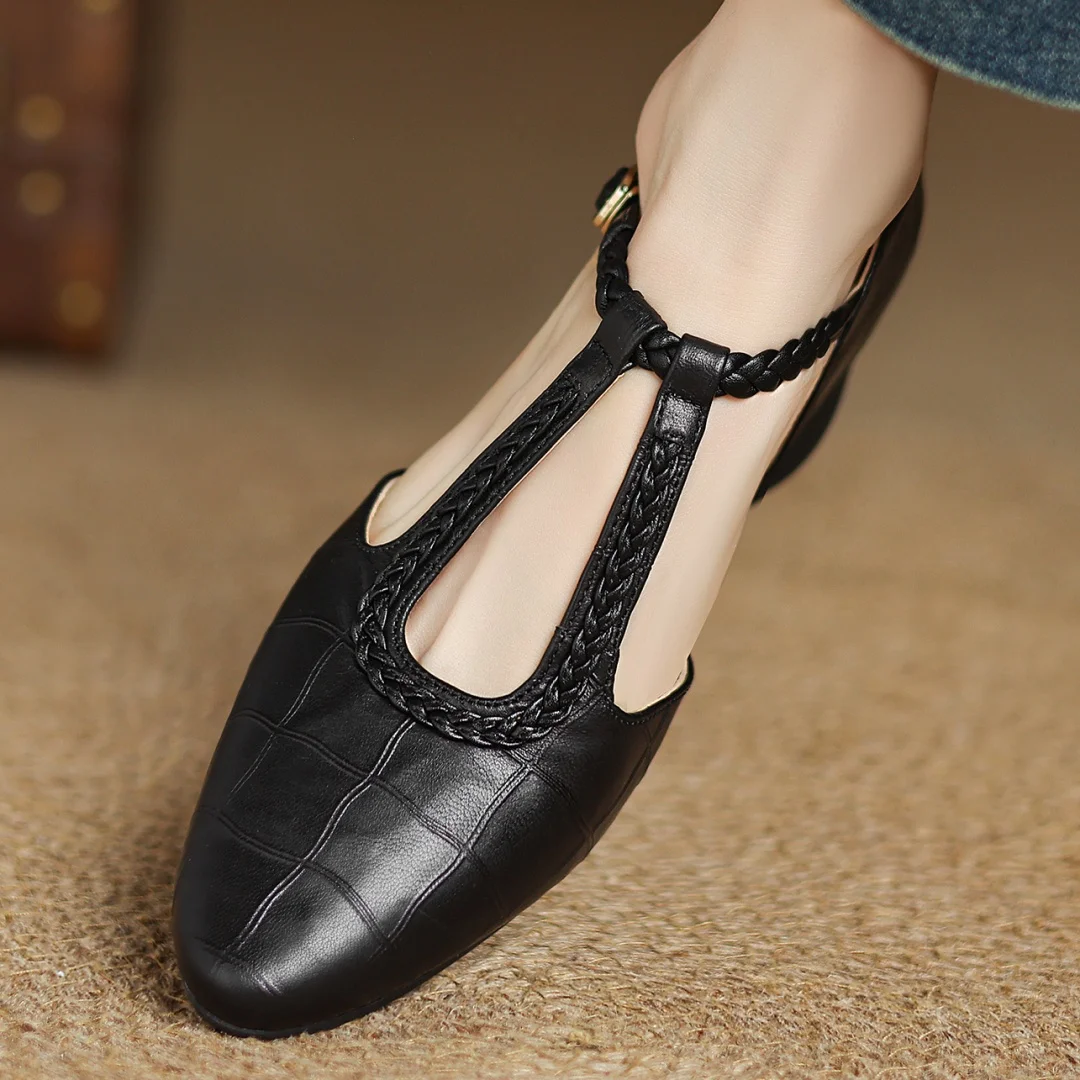 Pair of dark brown leather mary jane flats with pointed toe on neutral background