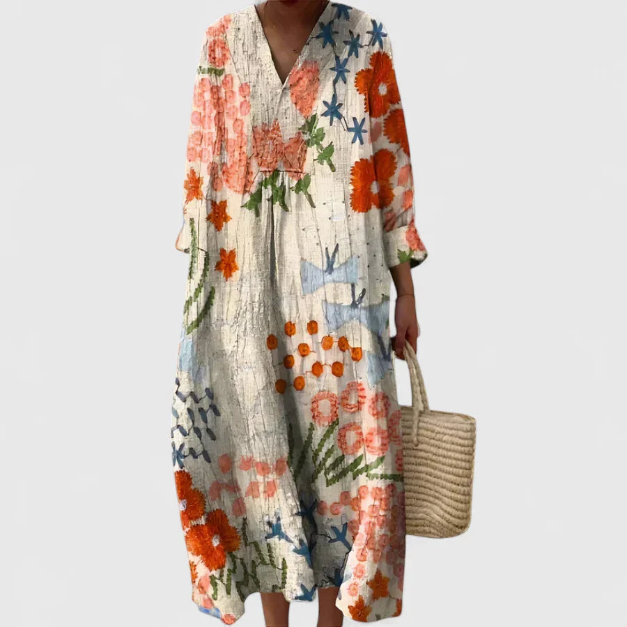 Emma wearing a Floral Summer Maxi Dress with coral and blue artistic blooms, V-neckline, and three-quarter sleeves in relaxed fit
