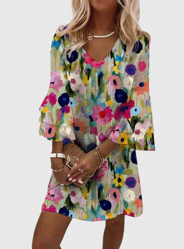 Woman wearing vibrant multicolor floral midi dress with V-neckline and three-quarter sleeves featuring abstract blooms