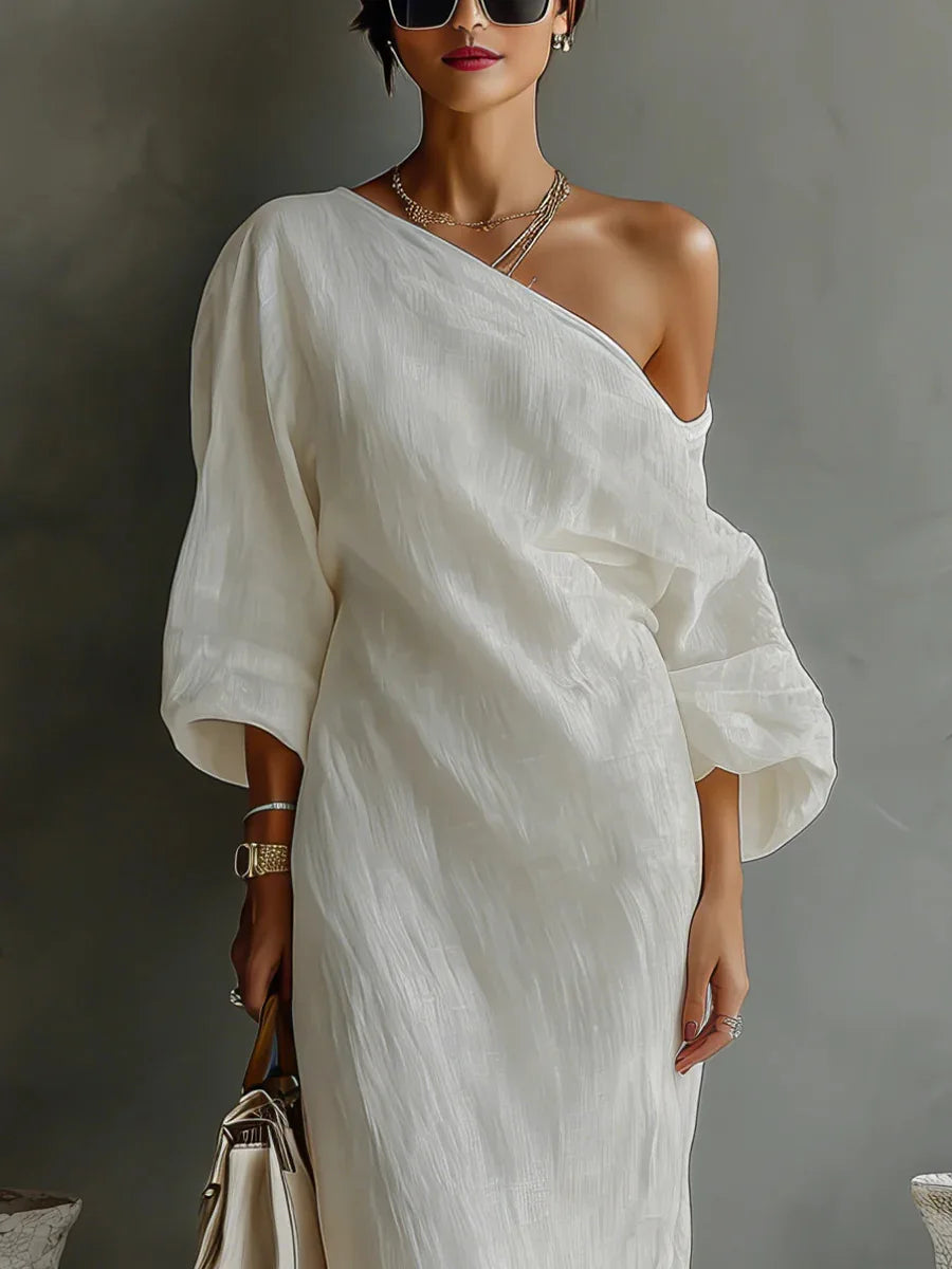 Side view of textured linen one shoulder dress showing batwing sleeve and fluid drape
