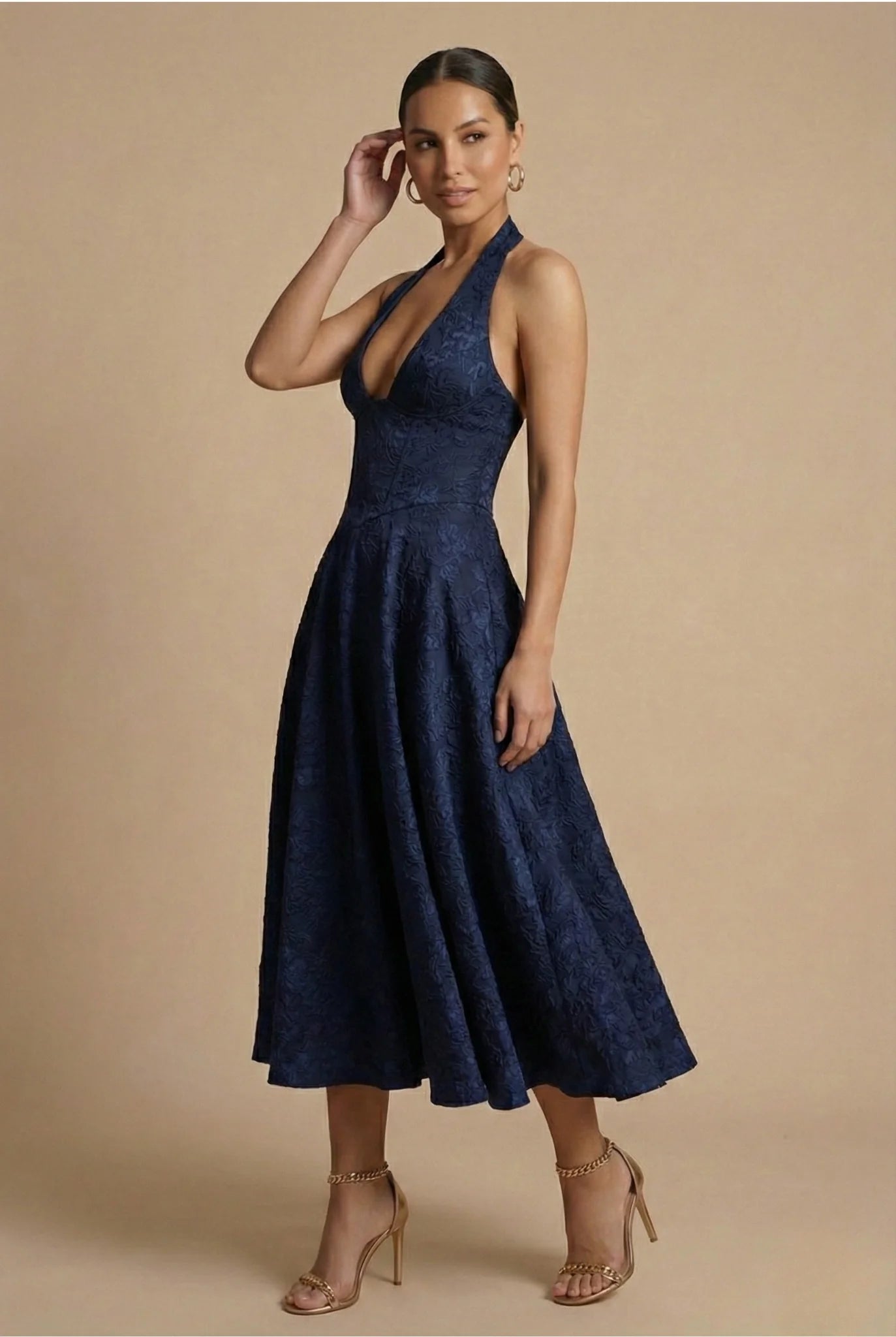 Model wearing halter midi dress styled with strappy heels for formal occasion