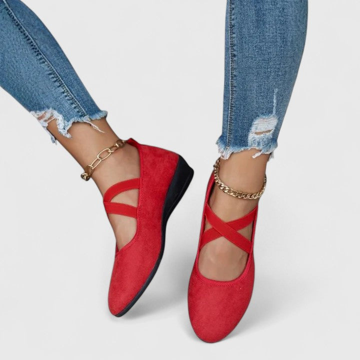 Women's cross strap flats styled with denim jeans and gold bracelet for casual everyday wear