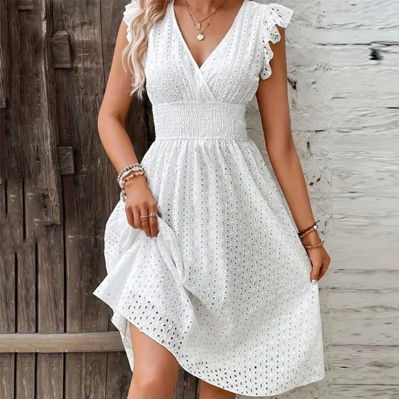 Woman wearing white V-Neck Summer Dress with eyelet texture and smocked waist on beach boardwalk