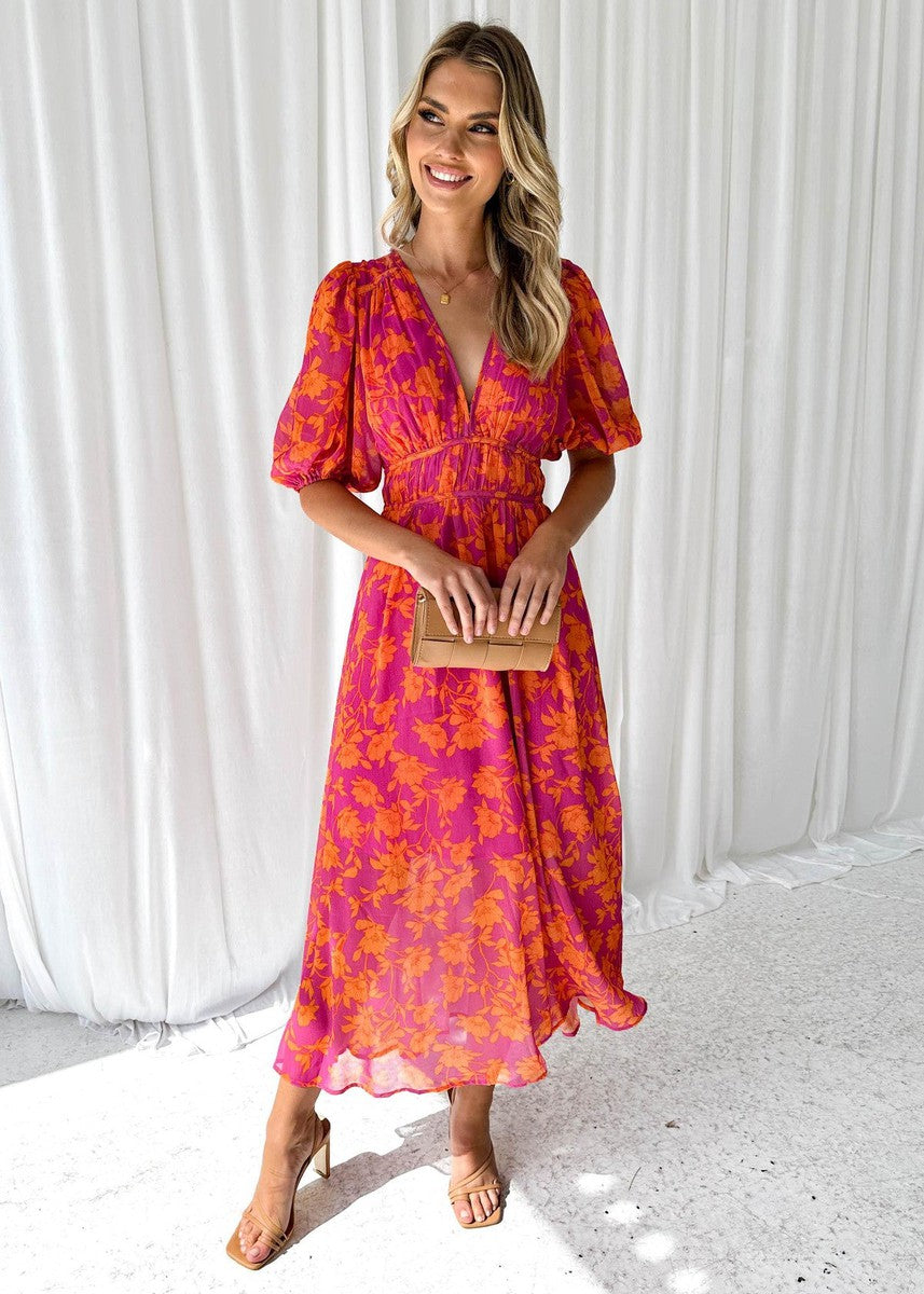 Side view of floral maxi wedding guest dress showing V-neckline and gathered empire waist detail