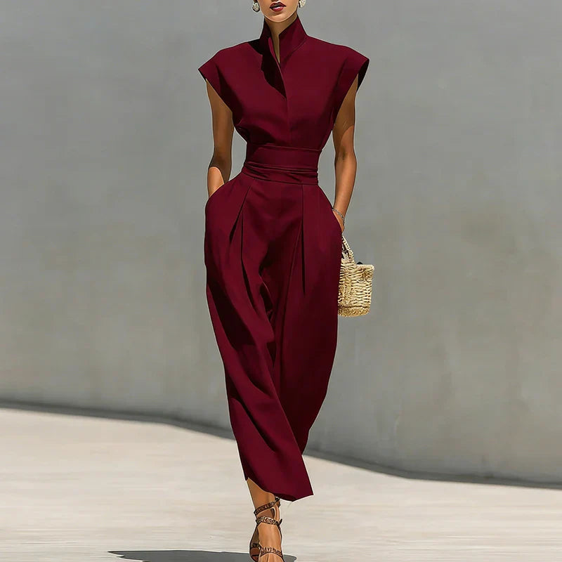 Woman wearing burgundy elegant midi dress with structured stand collar and cinched waist in natural light