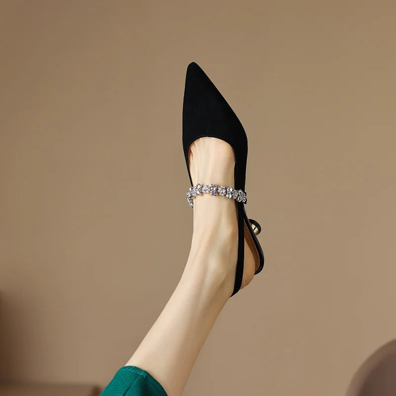 Side angle of women's pointed toe pumps showing crystal-adorned strap and glossy metallic finish