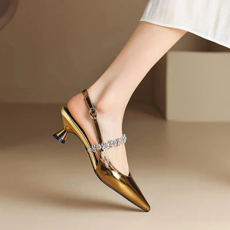 Detail of adjustable slingback closure and crystal-embellished instep strap on pointed toe heels