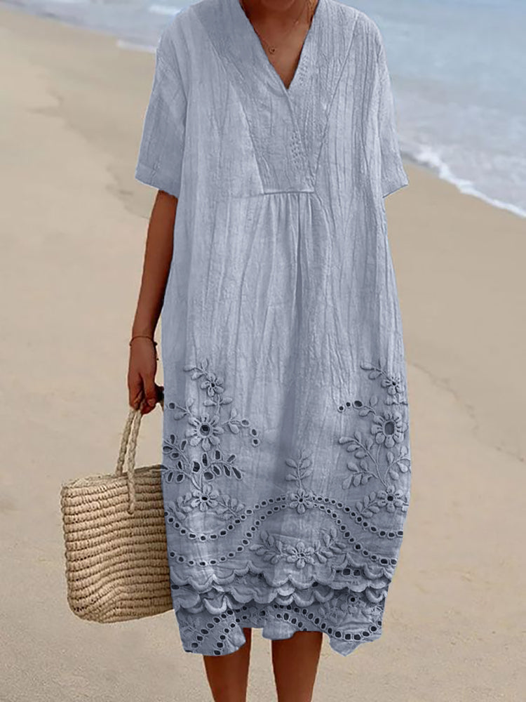 Close-up view of embroidered floral motifs and scalloped cutwork edging on midi summer dress hem