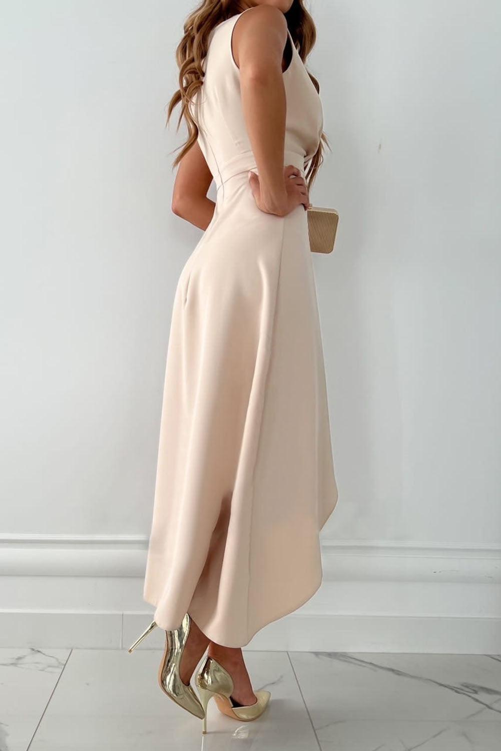 Side angle showing asymmetric hemline and structured drape of beige midi wedding guest dress