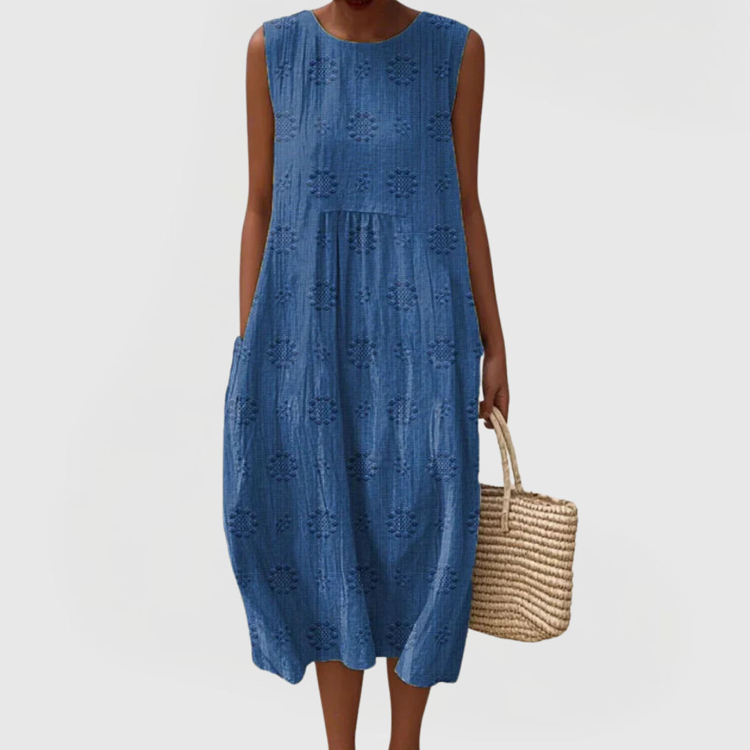 Close-up view of embroidered pattern on green linen midi dress with relaxed silhouette